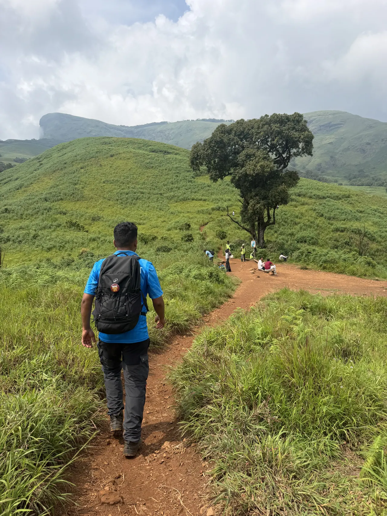 A trekker walking the grassland trail below Kudremukha peak